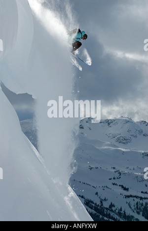 Una atrevida esquiador toma la zambullida apagado una cornisa en la montaña de Blackcomb Mountain, British Columbia, Canadá. Foto de stock