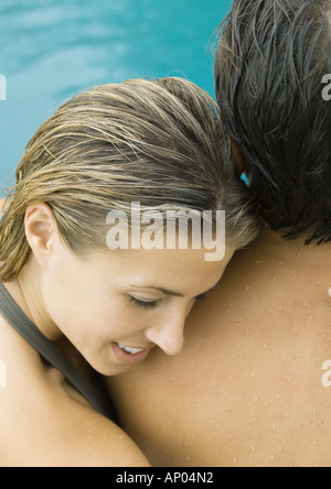 Par cerca de la piscina, mujer cabeza descansando sobre el hombro del hombre. Foto de stock