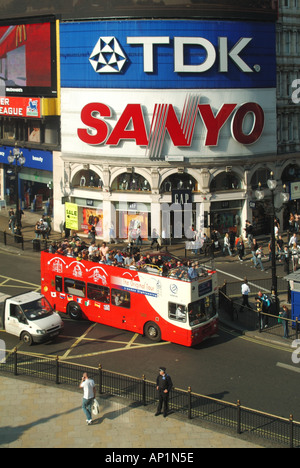 Vista aérea semi open top bus tour en Piccadilly Circus pasando publicidad iluminada acaparamiento Foto de stock