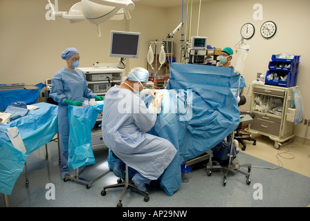El equipo quirúrgico, la realización de cirugía artroscópica de rodilla en el hospital quirófano Foto de stock