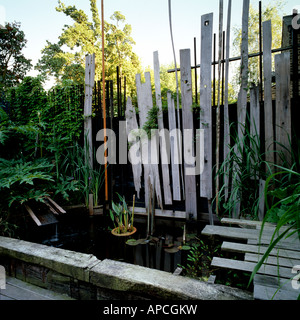 Londres reclamó jardín con cubierta de madera plantada con yuca y bajo crecimiento hierbas de Nueva Zelanda Foto de stock