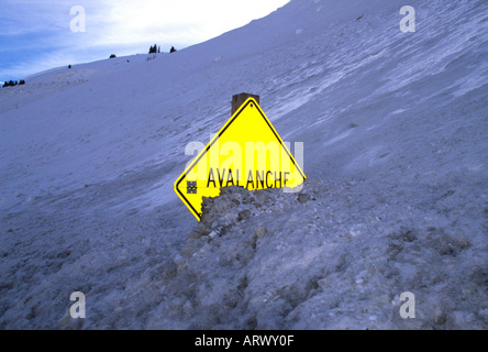 Una nieve parcialmente enterrada la autopista signo de advertencia de zona de avalancha en Loveland Pass Colorado Foto de stock