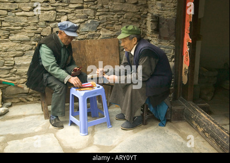 Dos ancianos concentrando en un juego Majhong.