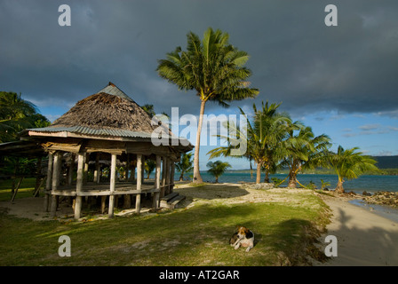 Normalmente fale en la playa de la isla de Upolu, Samoa beachfale namua NE costa noreste sol vespertino sunset sundown perro en las nubes frontal s Foto de stock