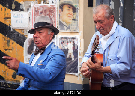Calle músico de tango: "Gardelito" cantando un tango canción con guitarra tradicional como su socio, en las calles de San Te Foto de stock