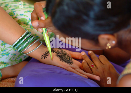 La mujer que recibe un tinte de henna mendhi ( ) diseño en su mano antes de su boda india