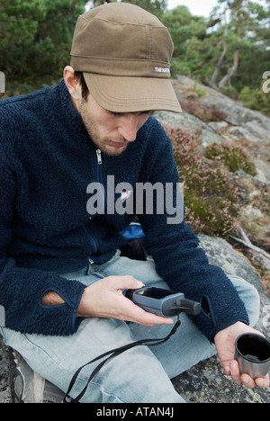 Joven excursionista verificando el curso sobre un receptor GPS negro en su mano derecha Bjorno Stockholms Lan Suecia en septiembre de 2007 Foto de stock