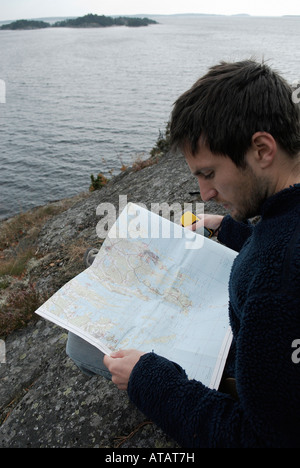 Joven excursionista verificando el curso con un mapa y un receptor GPS Bjorno Stockholms Laan Suecia en septiembre de 2007 Foto de stock