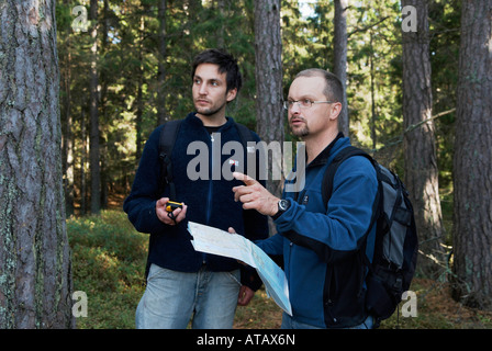 Excursionistas masculinos verificando el curso con un mapa y un receptor GPS Bjorno Stockholms Laan Suecia en septiembre de 2007 Foto de stock