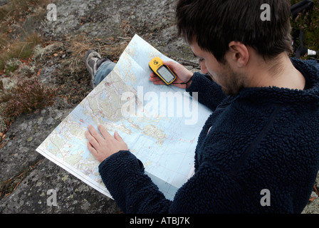 Joven excursionista verificando el curso con un mapa y un receptor GPS Bjorno Stockholms Laan Suecia en septiembre de 2007 Foto de stock