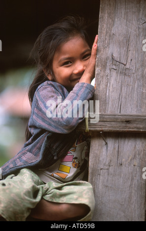 Joven chica loation en típica casa sobre zancos de madera en la remota aldea en el sur de Laos Foto de stock