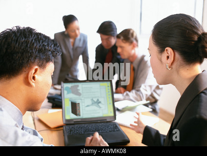 Asociados de negocios discutiendo la imagen visualizada en la pantalla de ordenador Foto de stock