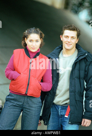Joven Hombre y Mujer de pie al lado vistiendo ropa de invierno Foto de stock