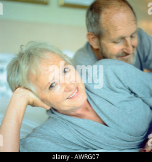 Las parejas ancianas acostado, mujer sonriendo a la cámara Foto de stock