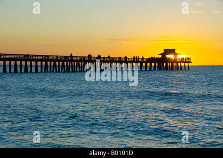 Puesta de sol sobre el Golfo de México y el embarcadero en Naples Beach, Florida, EE.UU. Foto de stock