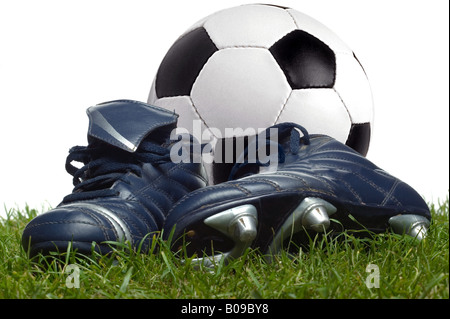 Un par de botas y un balón de fútbol en el césped, Foto de estudio