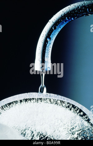 Grifo de agua gotee sobre hielo, close-up Foto de stock