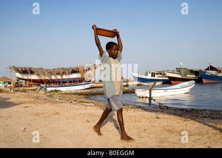 Chico llevando la cazoleta en Bocachica, Cartagena de Indias, Colombia Foto de stock