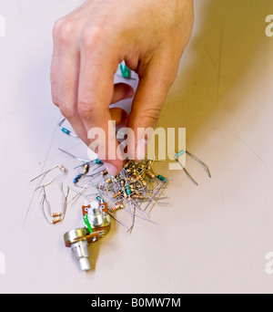 Una mano ordenar los componentes electrónicos. Foto de stock
