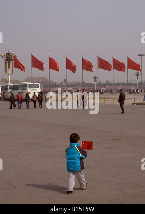 Chino niño sosteniendo la bandera de la plaza de Tiananmen, Pekín, China (primavera de 2008).