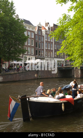 Un barco turístico en el canal de Prinsengracht, en el puente de Leliegracht Jordaan, Amsterdam, Países Bajos Foto de stock