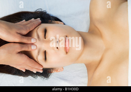 Mujer joven con masaje de cabeza en el health spa Foto de stock