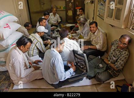 Los hombres de negocios con ordenadores portátiles sentarse en el piso en Chandni Chowk Vieja Delhi INDIA Foto de stock