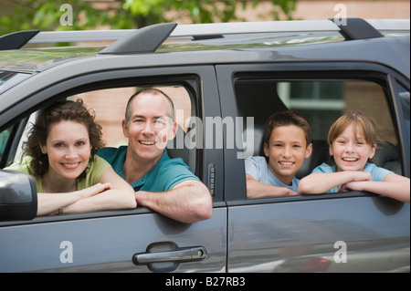 Familia con dos niños mirando las ventanas de autos