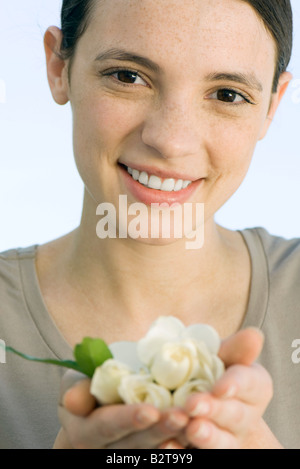 Mujer joven celebración puñado de capullos de rosa blanca. Foto de stock