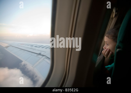 Niña mirando fuera de la ventana de un vuelo de Airbus