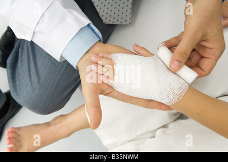 Doctor encintado de la mano del paciente en la gasa, un alto ángulo de visualización Foto de stock