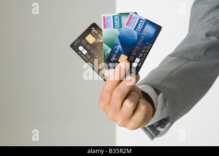 La mano del empresario la celebración de varias tarjetas de crédito, vista recortada Foto de stock