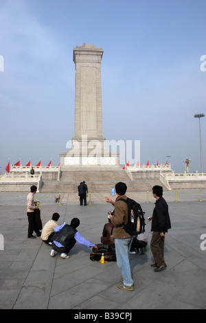 Los turistas stand y mirar hacia adelante en el monumento del pueblo''s héroes en la plaza de Tiananmen en Pekín, China Foto de stock