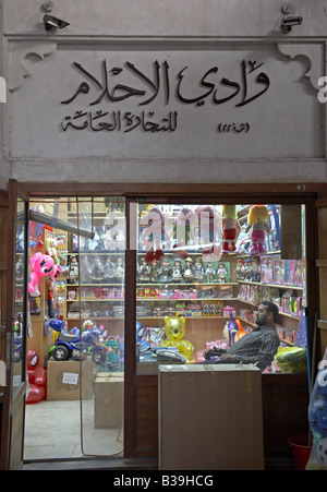 Propietario de juguetería descansando en su silla en Deira Souk Bazar Besitzer ruht sich en seinem Kinderspielzeugladen aus Foto de stock