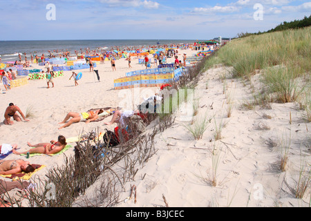 Playa Karwia Polonia sobre la costa del Mar Báltico, turistas y visitantes disfrutar del agosto de sol en las dunas de arena blanca y fina Foto de stock