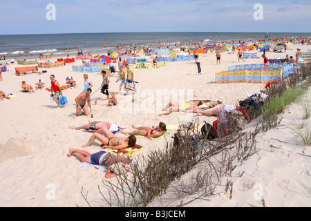 Playa Karwia Polonia sobre la costa del Mar Báltico, turistas y visitantes disfrutar del agosto de sol en las dunas de arena blanca y fina Foto de stock