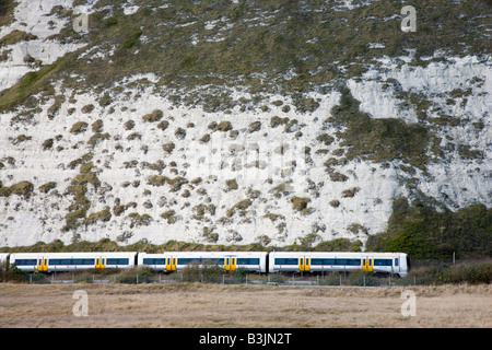 Tren Sprinter pasando bajo los acantilados blancos cerca de Dover. Foto de stock