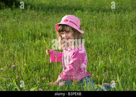 6-year-old girl recogiendo flores en un campo, Austria, Europa