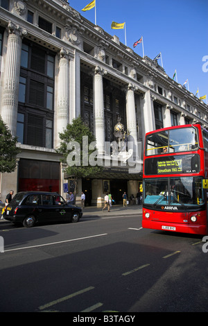 Inglaterra, Londres, double decker autobuses pasan fuera de los famosos grandes almacenes Selfridges en Oxford Street.