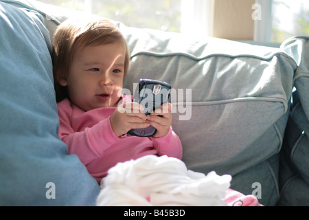 A 17 meses de edad niño niña es excitado por un correo electrónico que está leyendo en un dispositivo Blackberry. Foto de stock