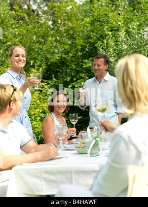 Cinco personas celebrando en una fiesta en el jardín