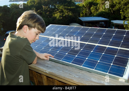 Boy examinando las células solares Foto de stock