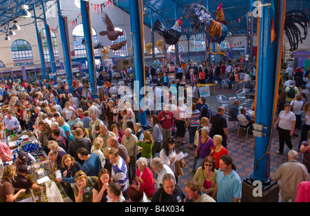 Multitudes de personas vagan sentarse y buscar puestos ain Market Hall en Abergavenny Festival de Comida Foto de stock