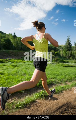 Mujer joven corriendo en trail Foto de stock