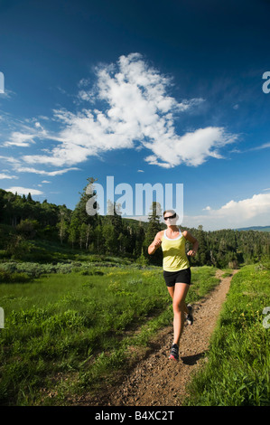 Mujer joven corriendo en trail Foto de stock