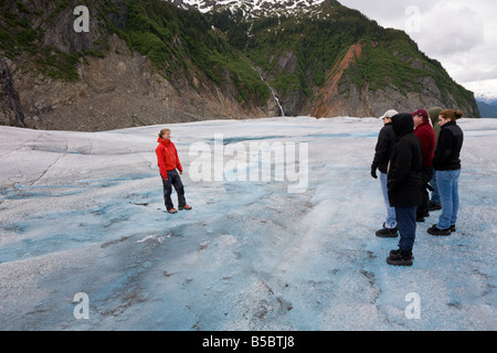 Guía de turismo en la parte superior del glaciar de Mendenhall, cerca de Juneau Alaska enseña y entretiene a los turistas. Foto de stock