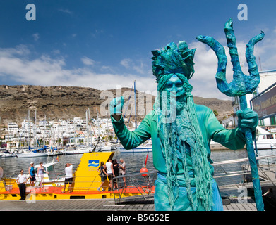 Artista de la calle vestida como Neptuno atraer turistas excursiones en barco por el Yellow Submarine en Puerto de Mogán Gran Canaria Foto de stock