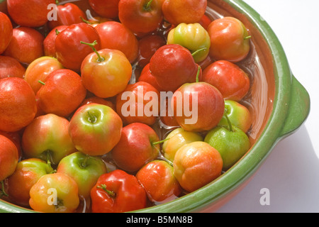 Acerola berris en un cuenco de cerámica Foto de stock