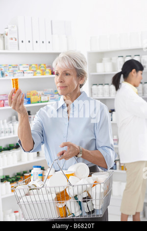 Cliente en Drug Store mirando en frascos de píldoras