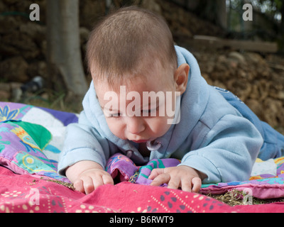 Curiosidades del bebé acostado en el suelo Foto de stock